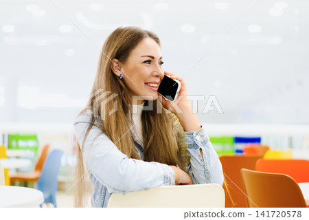 Customer Talking on Smartphone in Food Court Customer Talking on Smartphone in Food Court 141720578