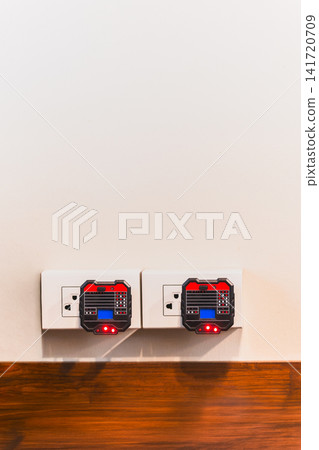 Two digital socket testers plugged into wall outlets to check electrical wiring. Two digital socket testers plugged into wall outlets to check electrical wiring. 141720709