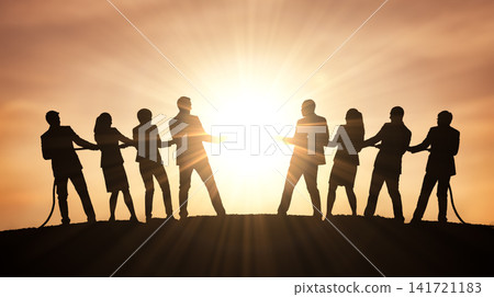 Rival business professionals actively pulling heavy rope opposite directions across outdoor dirt hilltop directly facing bright glowing evening sun displaying physical contest Rival business professionals actively pulling heavy rope opposite directions across outdoor dirt hilltop directly facing bright glowing evening sun displaying physical contest 141721183