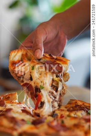Hot pepperoni pizza slice with melted cheese stretch being lifted. Perfect for restaurant, delivery, and comfort food imagery. Hot pepperoni pizza slice with melted cheese stretch being lifted. Perfect for restaurant, delivery, and comfort food imagery. 141721589