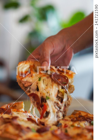 Hot pepperoni pizza slice with melted cheese stretch being lifted. Perfect for restaurant, delivery, and comfort food imagery. Hot pepperoni pizza slice with melted cheese stretch being lifted. Perfect for restaurant, delivery, and comfort food imagery. 141721590