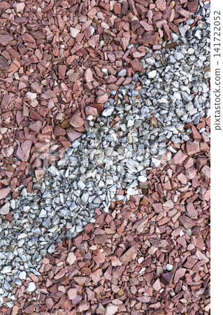 Top view texture of mixed red and gray crushed gravel stones. Ideal as natural background for construction, landscaping, architectural visualization, game assets, road materials, graphic design Top view texture of mixed red and gray crushed gravel stones. Ideal as natural background for construction, landscaping, architectural visualization, game assets, road materials, graphic design 141722052