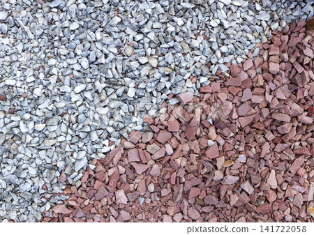 Top view texture of mixed gray and red crushed gravel stones. Ideal as natural background for construction, landscaping, architectural visualization, game assets, paving materials, graphic design 141722058