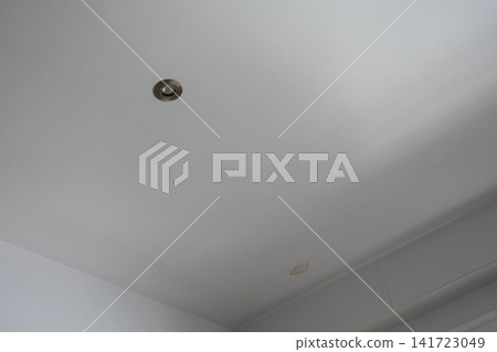 Brown water stain on a white kitchen ceiling caused by roof leak and moisture damage 141723049