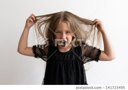 Spooky girl in witch costume pulling hair and roaring on white background 141723495