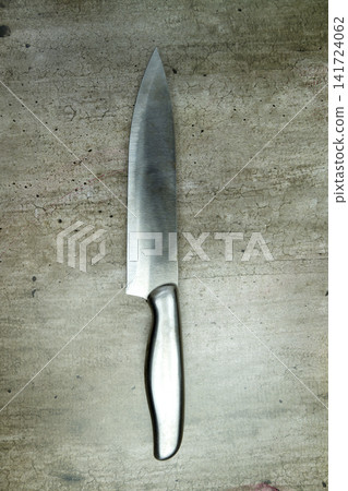 Sharp stainless steel chef's knife on a textured grey concrete background Sharp stainless steel chef's knife on a textured grey concrete background 141724062