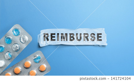 Flat lay of the word "REIMBURSE" on torn paper with pill blister packs on a blue background, representing medical cost refund. Concept of Reimburse Flat lay of the word "REIMBURSE" on torn paper with pill blister packs on a blue background, representing medical cost refund. Concept of Reimburse 141724104