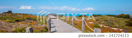 The wooden stairway at the rocky seashore on a sunny day. Polvoeira the beach. Pataias, Portugal, Europe The wooden stairway at the rocky seashore on a sunny day. Polvoeira the beach. Pataias, Portugal, Europe 141724213