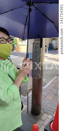 A woman walking in Isezaki-cho with a parasol and a handmade mask. A woman walking in Isezaki-cho with a parasol and a handmade mask. 141724361