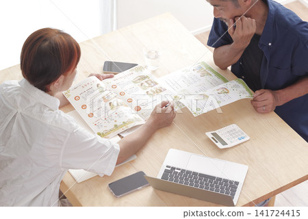 A couple discussing long-term care insurance and care services. A couple discussing long-term care insurance and care services. 141724415