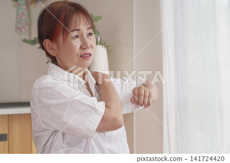 一位老年婦女,肩頸疼痛難耐。 一位老年婦女,肩頸疼痛難耐。 141724420
