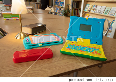 Colorful vintage learning toys on a cozy library table: a brightly lit scene with warm wood tones Colorful vintage learning toys on a cozy library table: a brightly lit scene with warm wood tones 141724544
