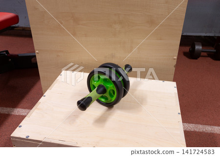 Ab roller on a wooden platform with natural light. Ab roller on a wooden platform with natural light. 141724583