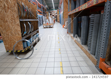 Wire and metal materials in a store aisle during the day with shelves filled with various supplies Wire and metal materials in a store aisle during the day with shelves filled with various supplies 141724597