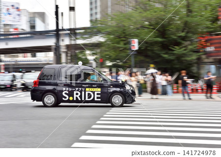 一輛計程車行駛在數寄屋橋十字路口的派出所前。 一輛計程車行駛在數寄屋橋十字路口的派出所前。 141724978