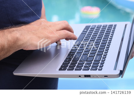 Laptop worker using laptop beside swimming pool, Laptop worker using laptop beside swimming pool, 141726139