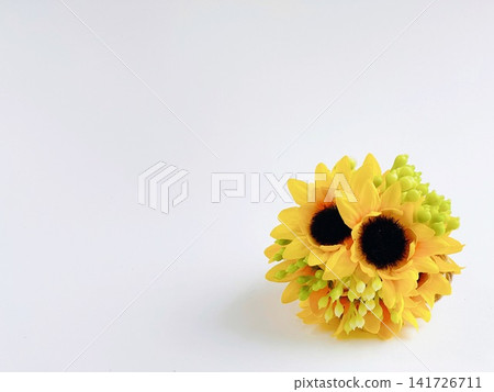 A bouquet of artificial yellow sunflowers set against a white background. A bouquet of artificial yellow sunflowers set against a white background. 141726711