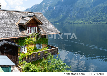 Hallstatt old traditional Wooden House with Wooden Balcony in Alpine Village rural landscape. Hallstatt, Austria lake water nature Hallstatt old traditional Wooden House with Wooden Balcony in Alpine Village rural landscape. Hallstatt, Austria lake water nature 141726901