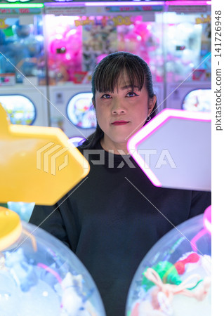 Portrait of Woman Behind Illuminated Gashapon Machines Portrait of Woman Behind Illuminated Gashapon Machines 141726948