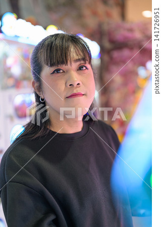 Close-Up Portrait of Asian Woman in Bright Arcade Close-Up Portrait of Asian Woman in Bright Arcade 141726951