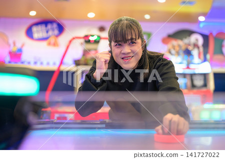 Cheerful Woman Celebrating Air Hockey Game Point Cheerful Woman Celebrating Air Hockey Game Point 141727022