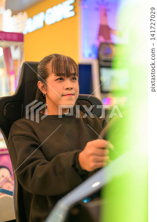 Focused Woman Playing Arcade Racing Game Focused Woman Playing Arcade Racing Game 141727029