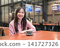 Portrait of a Confident Asian Woman Sitting in a Cafe with a Cup of Coffee 141727326