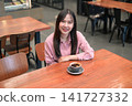 High Angle Portrait of a Smiling Asian Woman in a Cafe with a Cup of Coffee 141727332