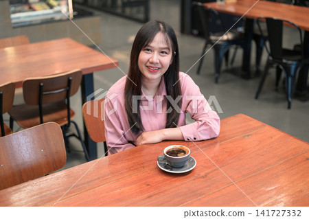 High Angle Portrait of a Smiling Asian Woman in a Cafe with a Cup of Coffee 141727332