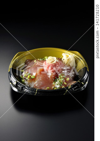 裝有金槍魚碎和醃金槍魚的便當盒,在黑色背景下拍攝。 裝有金槍魚碎和醃金槍魚的便當盒,在黑色背景下拍攝。 141728210