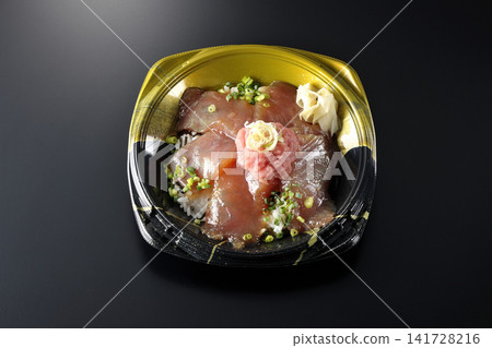 A photo of a negitoro and marinated tuna rice bowl bento box against a black background. A photo of a negitoro and marinated tuna rice bowl bento box against a black background. 141728216