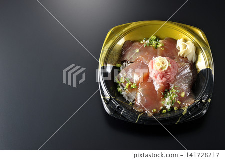 A photo of a negitoro and marinated tuna rice bowl bento box against a black background. A photo of a negitoro and marinated tuna rice bowl bento box against a black background. 141728217