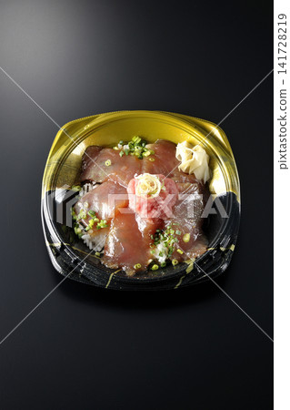 裝有金槍魚碎和醃金槍魚的便當盒，在黑色背景下拍攝。 141728219