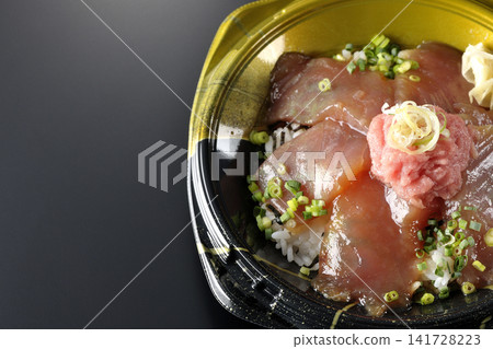 A photo of a negitoro and marinated tuna rice bowl bento box against a black background. A photo of a negitoro and marinated tuna rice bowl bento box against a black background. 141728223