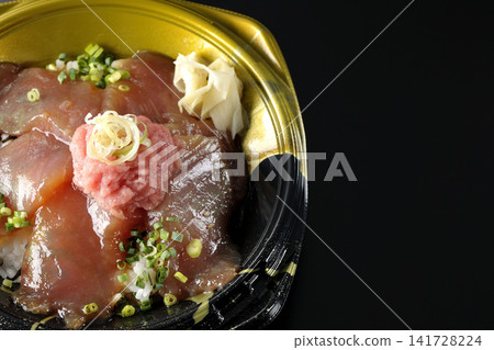 裝有金槍魚碎和醃金槍魚的便當盒，在黑色背景下拍攝。 141728224