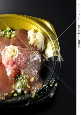 裝有金槍魚碎和醃金槍魚的便當盒，在黑色背景下拍攝。 141728227