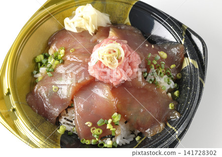 A photo of a bento box containing negitoro (minced tuna with green onions) and marinated tuna rice bowl against a white background. 141728302