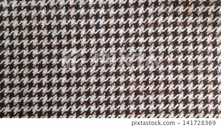 Macro of brown, beige, and white hounds tooth pattern with jagged interlocking four pointed checks. Slightly napped, fuzzy wool texture adds warmth and depth. Macro of brown, beige, and white hounds tooth pattern with jagged interlocking four pointed checks. Slightly napped, fuzzy wool texture adds warmth and depth. 141728369