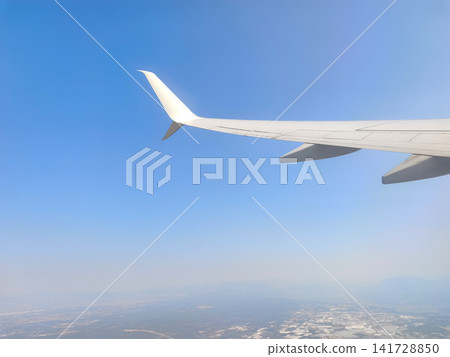 View from an Airplane Window with Wing and Clouds. View from an Airplane Window with Wing and Clouds. 141728850