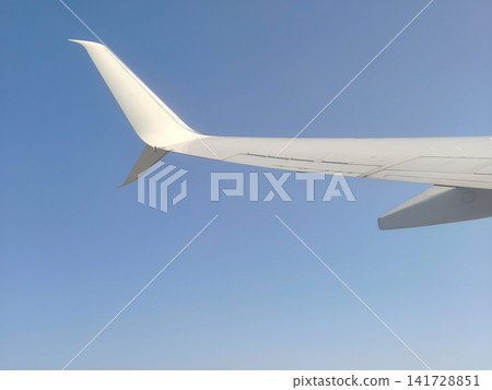 View from an Airplane Window with Wing and Clouds. View from an Airplane Window with Wing and Clouds. 141728851