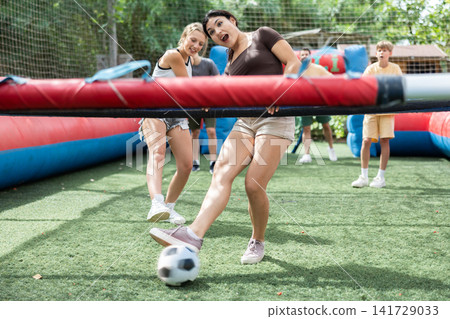 Group playing human table football with people holding bars in amusement park Group playing human table football with people holding bars in amusement park 141729033