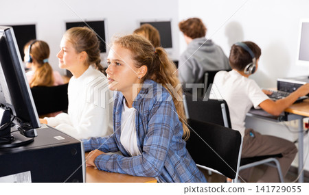 Portrait of a fifteen-year-old schoolgirl studying at a computer Portrait of a fifteen-year-old schoolgirl studying at a computer 141729055