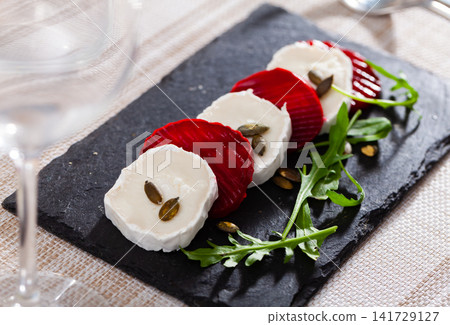 Portion of salad made of sliced beetroot and goat cheese Portion of salad made of sliced beetroot and goat cheese 141729127