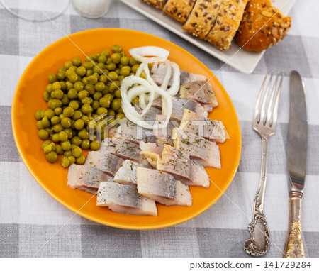 Sliced pickled herring fillet with greens peas and onions Sliced pickled herring fillet with greens peas and onions 141729284