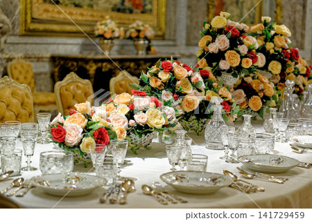 View of luxury crystal glassware and floral centerpieces on a banquet table at Waddesdon Manor View of luxury crystal glassware and floral centerpieces on a banquet table at Waddesdon Manor 141729459