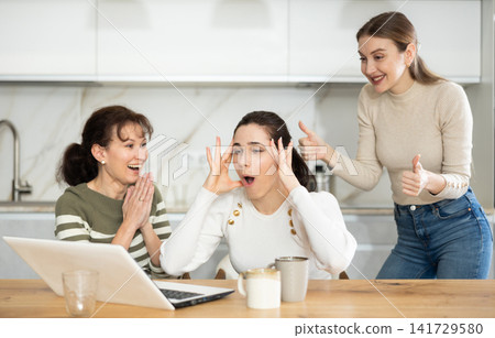Women are sitting at computer and are immensely happy Women are sitting at computer and are immensely happy 141729580