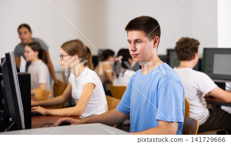Teenage boy using computer during lesson Teenage boy using computer during lesson 141729666