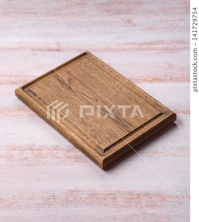 A square wooden cutting board for home food preparation. A wooden cutting board A square wooden cutting board for home food preparation. A wooden cutting board 141729754