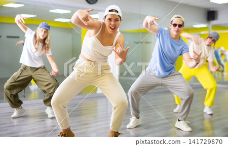 Expressive cool young dancers rehearsing their new dance during training together in studio 141729870