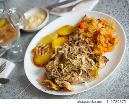 Juicy pork with potatoes and stewed cabbage Juicy pork with potatoes and stewed cabbage 141729875